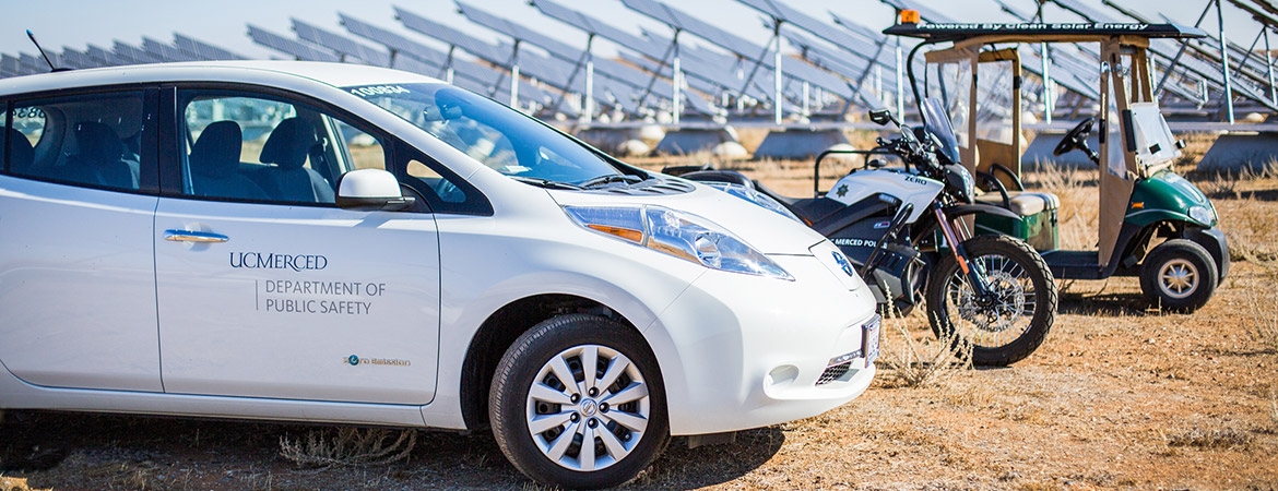 Image of university vehicles parked by solar array